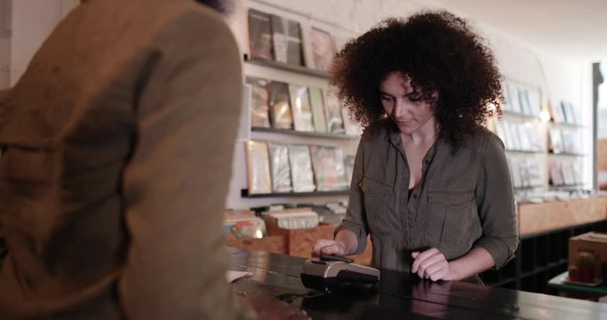 Customer making payment with smartphone in a record store
