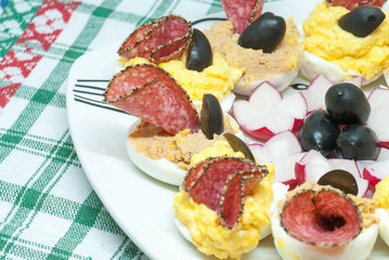 delicious stuffed boiled half eggs with different fillings yolk mixed with cheese or liver pate and decorated with salami and black olives
