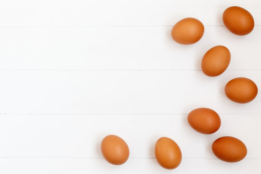 fresh or raw brown eggs on white wooden background, top view, flat lay with copy space, food ingredient