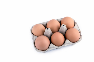 Close-up view of raw chicken eggs in box on white background.