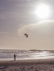 Obraz premium Boy launches a kite on the seafront. Kid having fun outdoors. Concept: summer vacation, happiness.