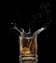 Isolated shot of whiskey with splash on black background