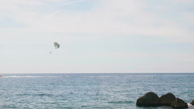 Parasailing water amusement. Flying on a parachute behind a boat in Montenegro