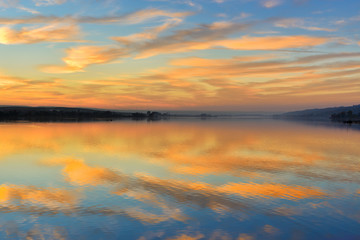 Fototapeta na wymiar Calm Lake at Sunset, Clouds Reflecting in the Water
