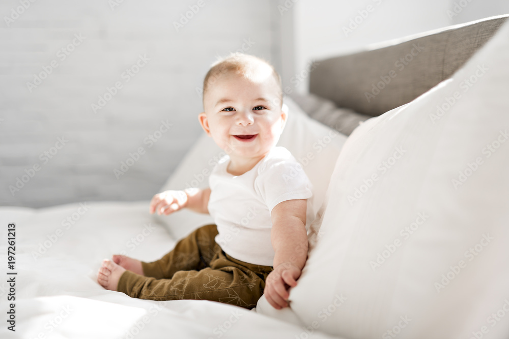 Wall mural Portrait of a baby boy on the bed in bedroom