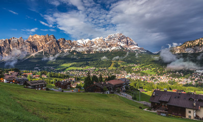 Cortina d'Ampezzo town panoramic view with alpine green landscape and massive Dolomites Alps in the background. Province of Belluno, South Tyrol, Italy.