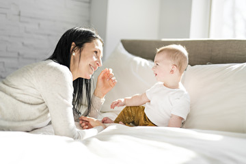 Obraz premium Mother with a baby on bed at home