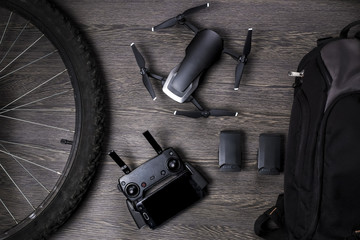 drone and bicycle wheel, near a backpack and battery, with a leaf for planning, on a woody...