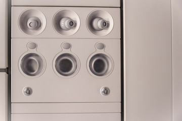 airplane cabin interior detail. Overhead console in the modern passenger airplane with air conditioner and lightings