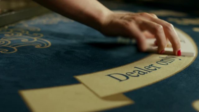 Casino dealer woman shuffles the poker cards and performing trick with cards.