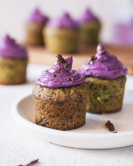 Spinach delicious muffins with blueberry filling, topped with grated chocolate on a white background. Vertical. Close up.