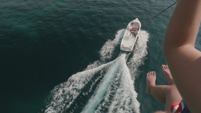Parasailing water amusement. Flying on a parachute behind a boat in Montenegro
