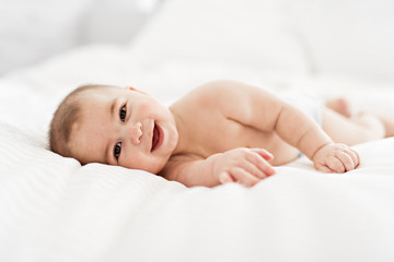 Portrait of a baby boy on the bed in bedroom - obrazy, fototapety, plakaty