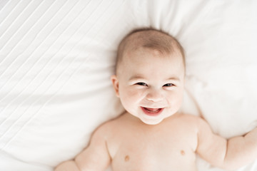 Portrait of a baby boy on the bed in bedroom