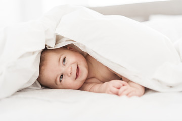 Portrait of a baby boy on the bed in bedroom