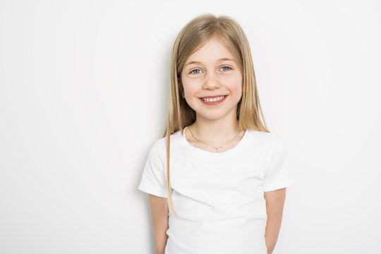 Happy small five years old girl with straight hair over white background at home