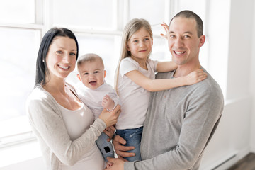 Family of four on a beautiful room with white window