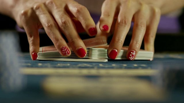 Casino: Dealer woman shuffles the poker cards. Shot on RED EPIC DRAGON Cinema Camera in slow motion.