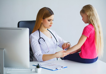 Pediatrician doctor examining little girl