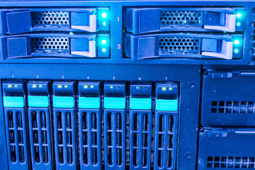 A large server with a lot of slots for hard drives works in the server room of the data...