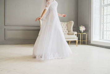 Fototapeta na wymiar bride is going in wedding dress indoor in studio
