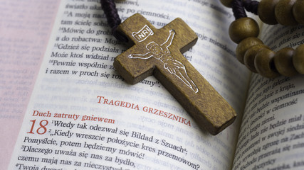 cross from rosary on the polish bible -  Book of Job, tragedy of the sinner © Bartosz