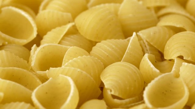Raw conchiglie rigate closeup macro revolving on a turntable. Shallow depth of field. Low angle. Not loopable.