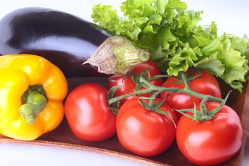 Fresh assorted vegetables, eggplant, bell pepper, tomato, garlic with leaf lettuce. Isolated on white background. Selective focus.