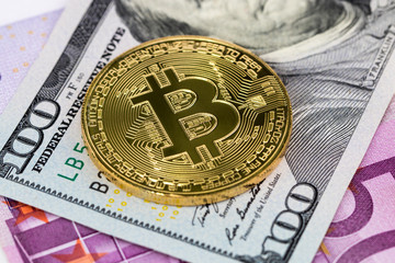 golden bitcoin metallic coin over dollar and euro banknotes