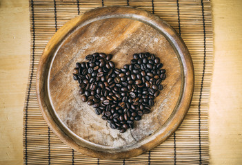  coffee beans on the wooden cutting board in shape heart