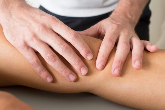 Masseur macht eine Kniemassage