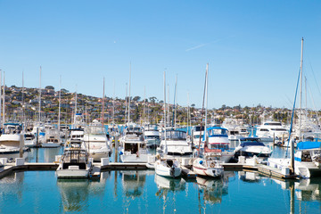 Fototapeta na wymiar Many boats at San Diego California marina district with the hills of Point Loma in the background