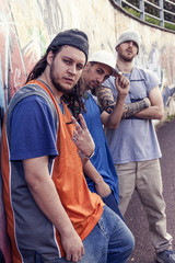 three rap singers in a subway with graffiti in the background