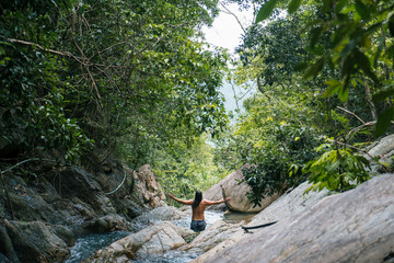 Man Standing and Cheering in a Waterfall