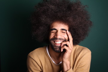 Afro man in front of a green background