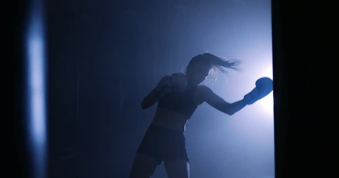 Silhouettes of a boxer in a dark smoky room