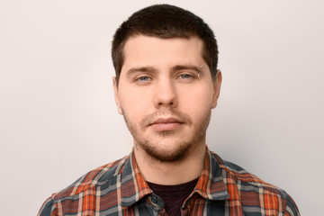 Obraz premium Young man with pierced eyebrow on light background