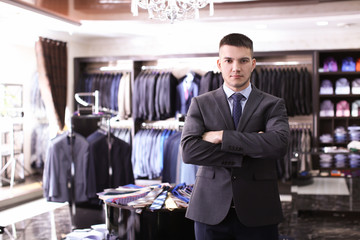 Fototapeta na wymiar Young man wearing elegant suit in boutique