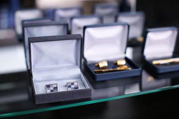 Boxes with cufflinks on shelf in boutique