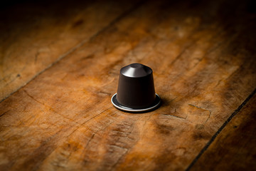 coffee pod on wooden table, hero shot.