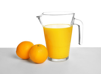 Jug with orange juice and fresh fruits on white background