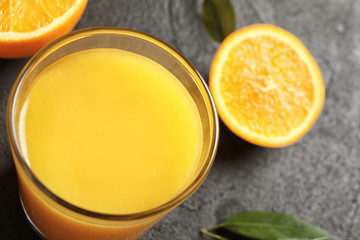 Glass of orange juice on grey background, closeup