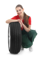 Fototapeta premium Female mechanic with car tire on white background