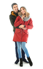 Young couple in warm clothing on white background. Ready for winter vacation