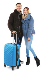 Young couple with suitcase on white background. Ready for winter vacation © New Africa
