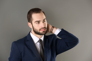 Portrait of young businessman with beautiful hair on grey background