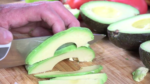 Slicing a fresh avocado on a cutting board