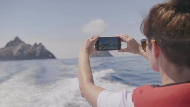 Woman On Boat Filming Skellig Michael Island With Smartphone