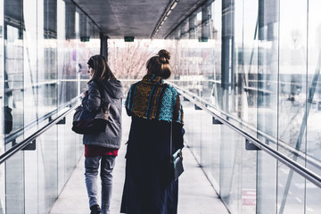 two women walking in a tunnel made of glass