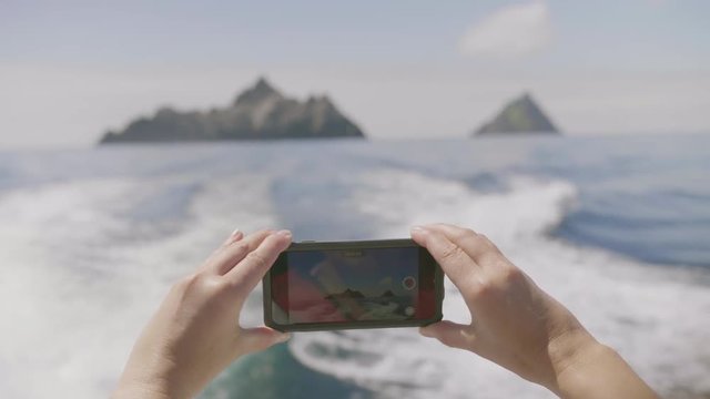 POV Shot Of Woman Filming Skellig Michael Island With Smartphone
